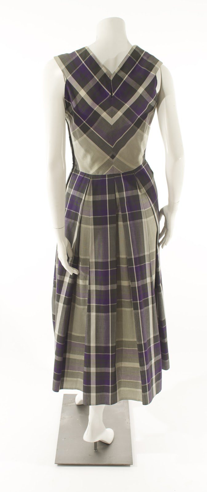 Claire McCardell fashion designs plaid dress with bias-cut bodice and straight-grain pleated skirt